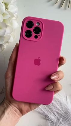 a woman's hand holding an iphone case with the back cover in bright pink