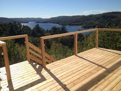 a wooden deck with railings overlooking a lake