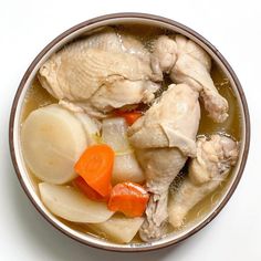 a close up of a bowl of food with chicken and carrots on the side