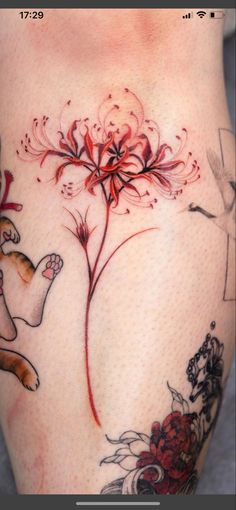 a woman's thigh with tattoos on her legs and an image of a flower