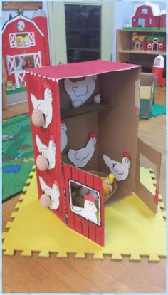 an open cardboard box sitting on top of a wooden floor in a room filled with toys