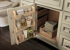 an open cabinet in a bathroom next to a toilet