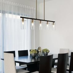 a dining room table with chairs and vases on it