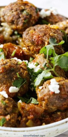 meatballs with feta cheese and herbs in a bowl