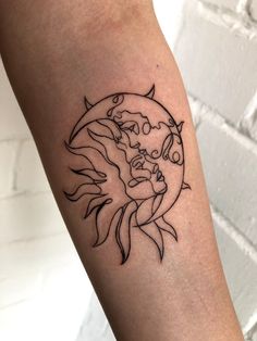 a woman's arm with a tattoo on it that has a sun and moon in the middle