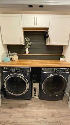 a washer and dryer in a small room with white cabinets on the wall