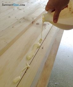 someone is pouring white sauce on top of some wood planks to make something interesting