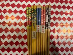 a bunch of chopsticks sitting on top of a red and white wall