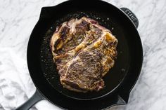 a steak is cooking in a black skillet