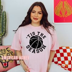 a woman wearing a pink t - shirt with the slogan tis the season printed on it