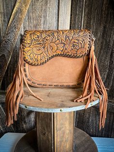 Made of PU leather (suede-feel), this western crossbody has: Sunflower tooled on saddle shape flap with magnetic button closure Whipstitch detail Fringe Top zipper closure Inside of the bag includes a zippered pocket and 2 open pockets A zippered pocket on the back A detachable and adjustable crossbody strap included 10" x 3" x 8" (Drop 24") Swim Belts, Hay Bag, Spur Straps, Wrap Boots, Silver Jewelry Box, Horse Boots, Horse Blankets, Fringe Top, Dog Collars & Leashes