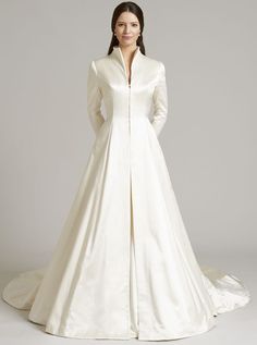 a woman in a white wedding dress with long sleeves