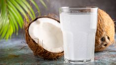 a glass of water next to a half eaten coconut