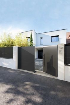 the entrance to a modern house with black and white accents on the walls, doors and windows