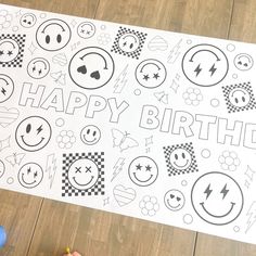 a child's hand holding a marker next to a large happy birthday poster on the floor