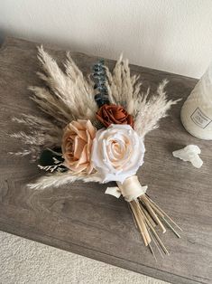 an arrangement of flowers and feathers on a table