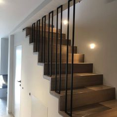 the stairs are made of wood and have metal railings on them, along with white walls