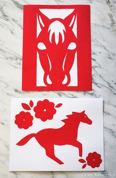 two red and white paper cut outs sitting on top of a marble table