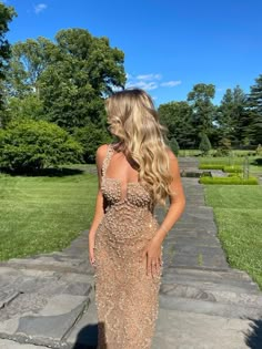 a woman in a long dress is standing on some steps and looking down at the ground