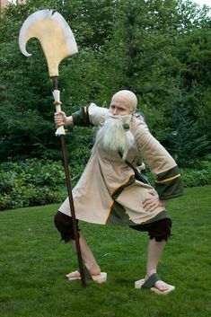 a man dressed as an old - fashioned wizard holding a giant sculpture