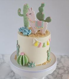 there is a cake decorated with cactuses and other decorations on top of the cake