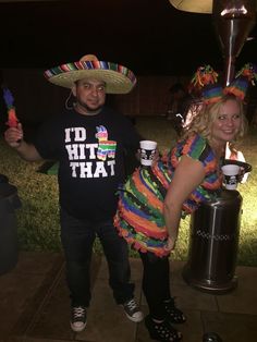 a man and woman dressed up in mexican attire posing for the camera with their drinks