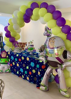 an inflatable buzz lightyear balloon arch and table set up for a toy story birthday party