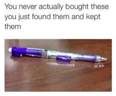 a purple pen sitting on top of a wooden table next to an advertise