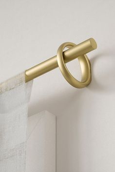 a gold curtain rod is hanging on the wall