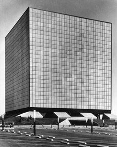 an old black and white photo of a large building with many windows on the side