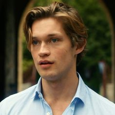 a close up of a person wearing a blue shirt and looking off to the side