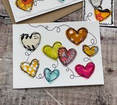 two cards with hearts on them sitting next to each other, one has been made out of paper and the other is handmade