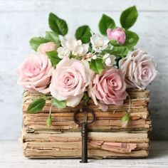 a bunch of flowers that are on top of some kind of book with a key in it