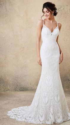 a woman in a white wedding dress posing for the camera with her hand on her hip