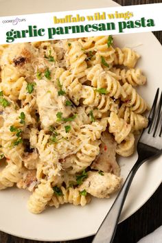 pasta with chicken and parmesan cheese on a white plate next to a fork