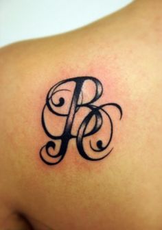 a tattoo on the back of a woman's shoulder that has an initial letter b