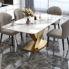 a marble dining table with gold legs and grey chairs in a modern style kitchen area