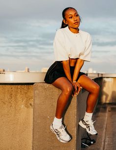 a woman sitting on top of a cement wall