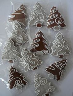 several decorated cookies in plastic wrappers on a white tablecloth with brown and white designs