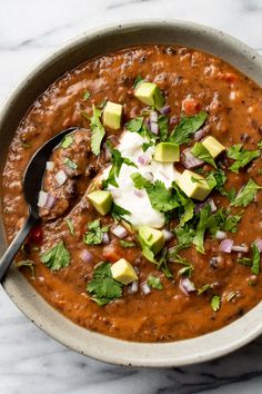 a bowl filled with beans and avocado garnished with cilantro