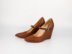 Step out in style with these Vintage Leather Wedge Heels with Ankle Strap in Brown by Cascade. Featuring a sleek pointed toe and a secure ankle strap with a delicate buckle, these shoes are perfect for both casual and formal occasions. The high wedge heel offers stability and comfort, making them ideal for all-day wear. Crafted from high-quality materials, these heels combine durability with timeless style, ensuring they remain a versatile addition to your wardrobe. Brand: Cascade Condition: USE Elegant High Heel Platform Wedge Boots, Closed Toe Wedge Sandals For Work, Chic High Heel Wedge Sandals For Work, Elegant Wedge Heel Sandals For Work, High Heel Wedge Boots For Office, Elegant Medium Width High Heel Wedge Boots, Office Platform Wedge Heels, Office Platform Wedge Heel, Elegant Wedge Heel Boots For Spring