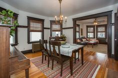 a dinning room table with chairs and a rug on the floor in front of it