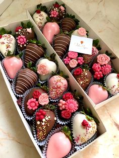 two boxes filled with chocolate covered strawberries and flowers