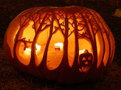 a carved pumpkin with candles in it on the ground