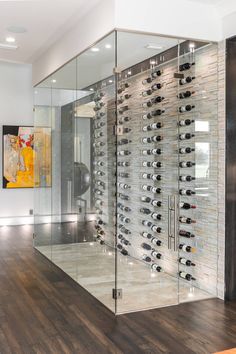 a wine cellar with glass walls and wooden floors