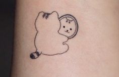 a small tattoo on the wrist of a person with a bear holding a mirror in it's hand