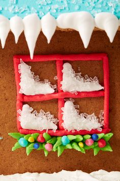 a gingerbread house with icing and decorations on the outside, decorated in white frosting