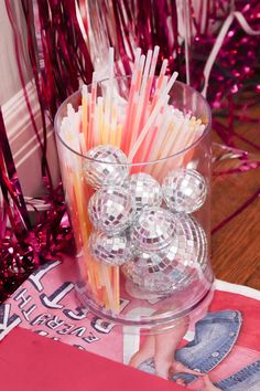 a glass vase filled with lots of different colored straws