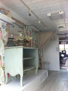 an old fashioned dresser is in the corner of a room with floral wallpaper on the walls