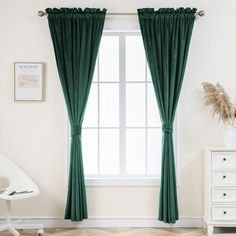 a room with white furniture and green curtains